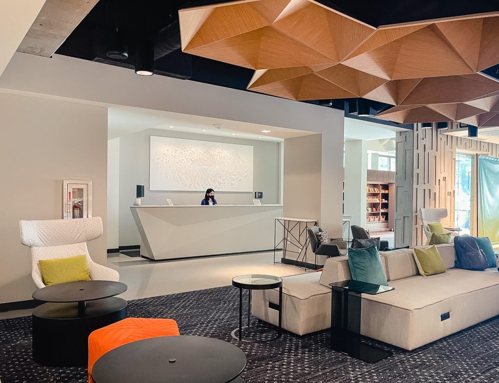 bright modern decor in a hotel lobby, with front desk clerk behind desk