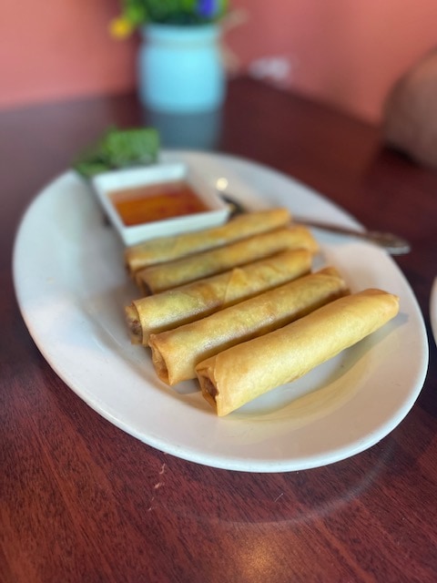 five spring rolls on a plate with chili sauce on the side at simply thai restaurant near southcenter